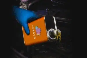 ruka držící motorové plechovky od oleje